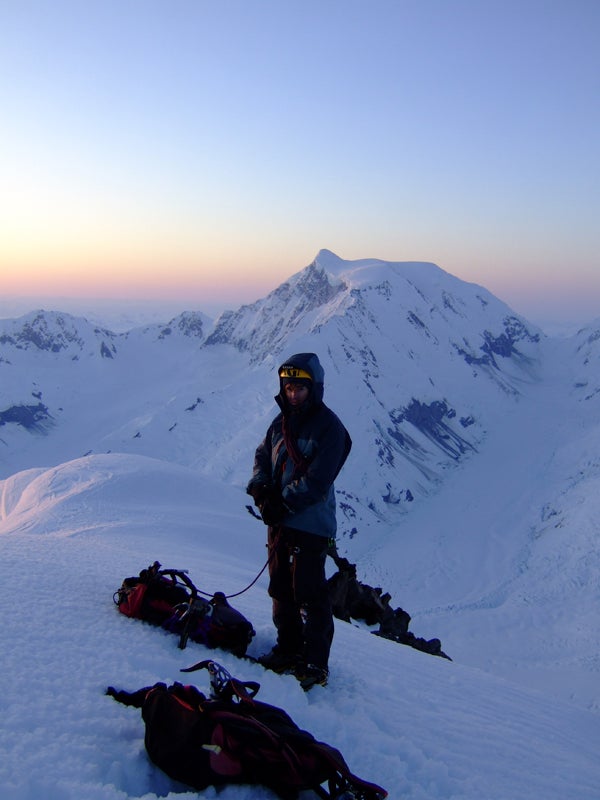Guy McKinnon on the summit of Peak 8,59 Guy McKinnon on the summit of Peak 8,599' at sunrise, with Mt. Bertha in the background. Photo by Paul Knott.