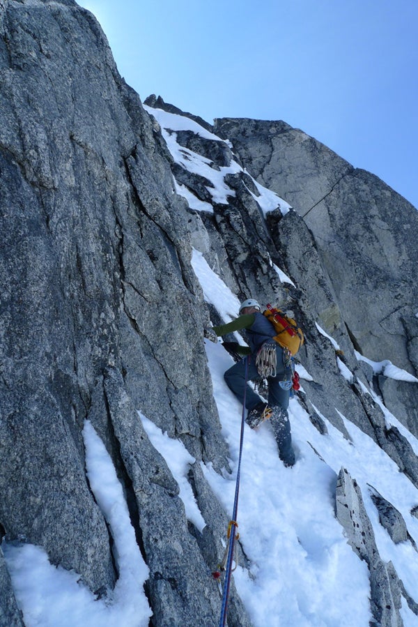 John Frieh leading a mixed step on the John Frieh leading a mixed step on the west ridge. The climbers changed between mountain boots and rock shoes several times during the ascent. Photo…