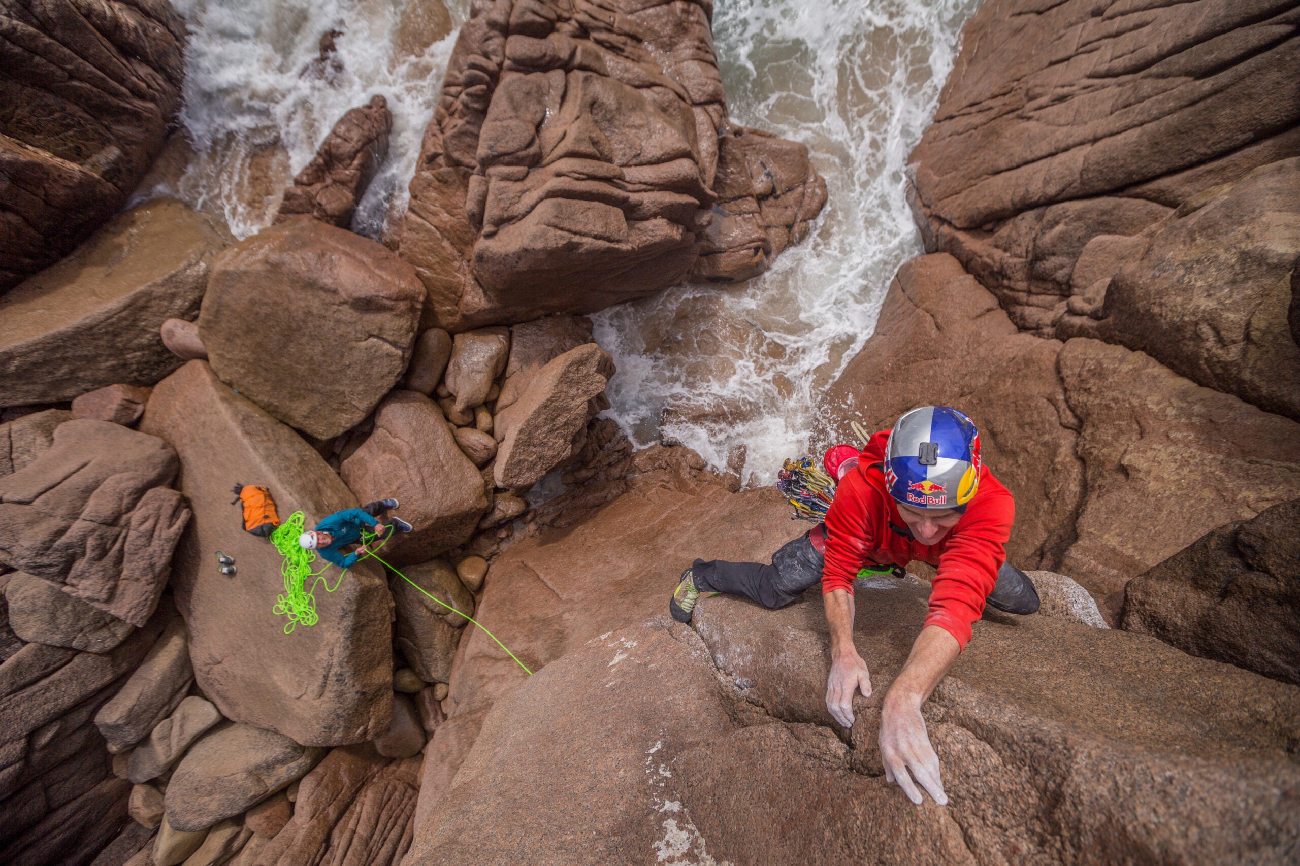 Man rock climbs with a helmet.