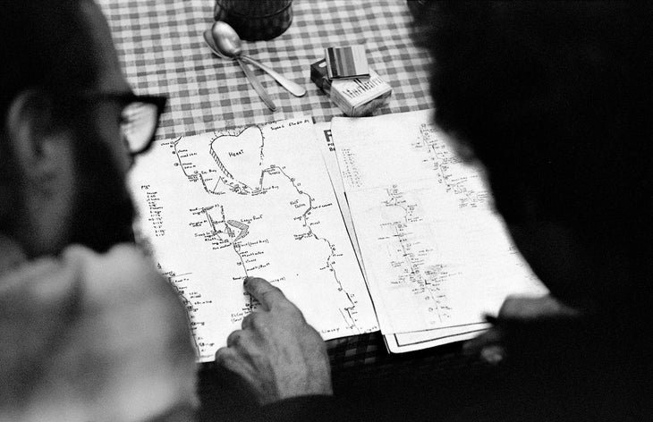 Old school Yosemite Climbers looking at a hand-drawn topographical map of the Salathe Wall, preparing for an ascent