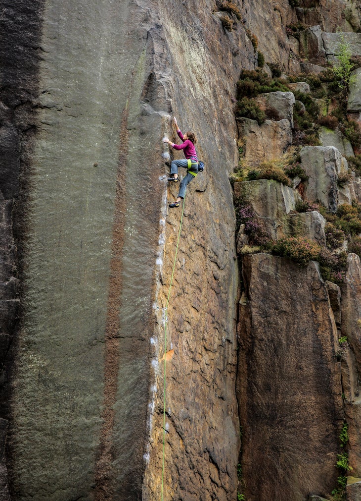 _34A7703_Millstone_E7 (1) a woman climbing a dangerous arete on gritstone