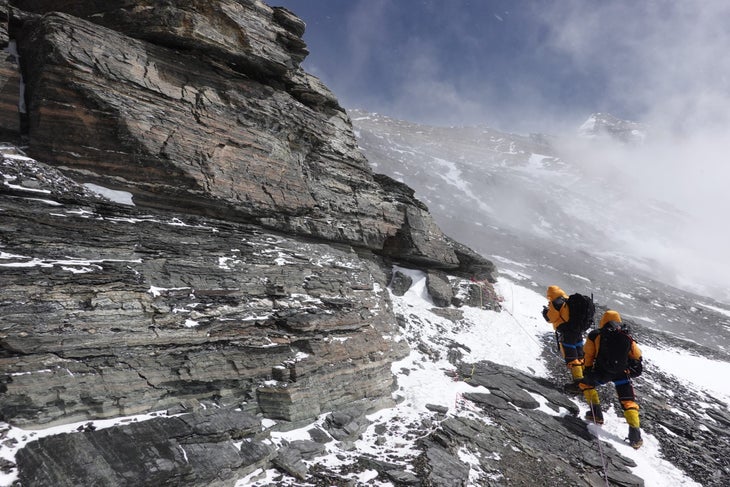 Mark Synnott took this photo at approximately 8,000 meters in an area called the Sidewalk. The two climbers in the shot are Renan Ozturk and Matt Irving. This photo was taken close to the spot where Noel Odell made his famous last sighting high on the Northeast Ridge. Through the mist you can see the summit, and all three of the famous steps. The Second Step is the small toothy bit directly over Renan’s head, who is in the lead. Synnott, Ozturk, Irvine and co. were on their way to Camp 3, which is situated at 27,200 feet.