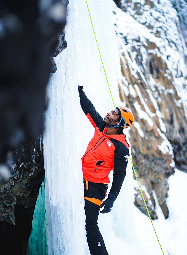 Fred Campbell, a climbing guide for Climbers of Color, instructing on ice tool placement.