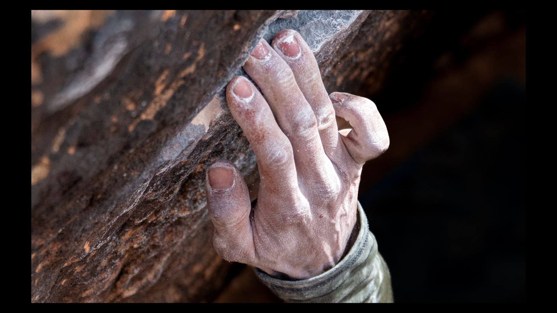 A climber's fingers on a small hold—about to snap off of it in a way that can cause arthritis.