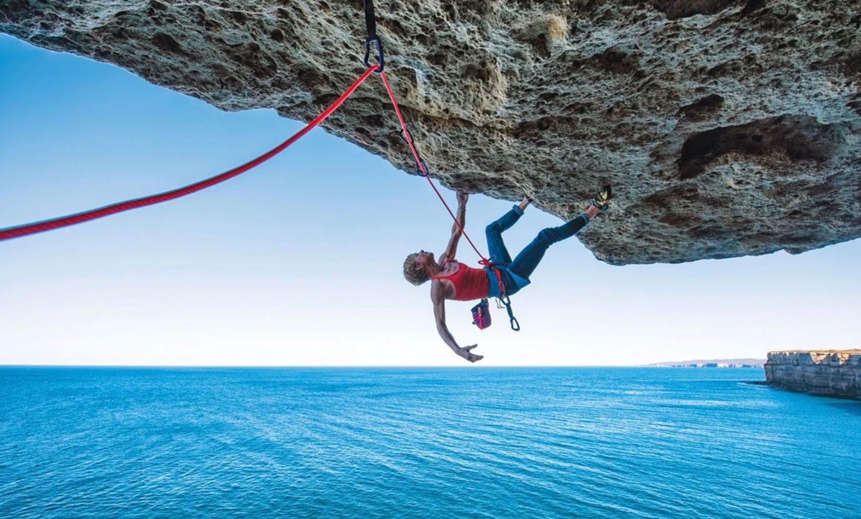 Three hours south of Sydney, the majestic 300-foot-high sandstone sea cliffs at Point Perpendicular present a playground with miles of cliffline above the churning sea. The Point yields some 500 routes from short sporty pump fests to multi-pitch trad epics; most somewhat split the difference. In this image Monique Forestier fights lactic acid on the roof Footloose and Fancy Free (22/5.11b). Although a sport climb, Footloose requires a committing rappel to a ledge. Ocean, sky, roof and complete seclusion.