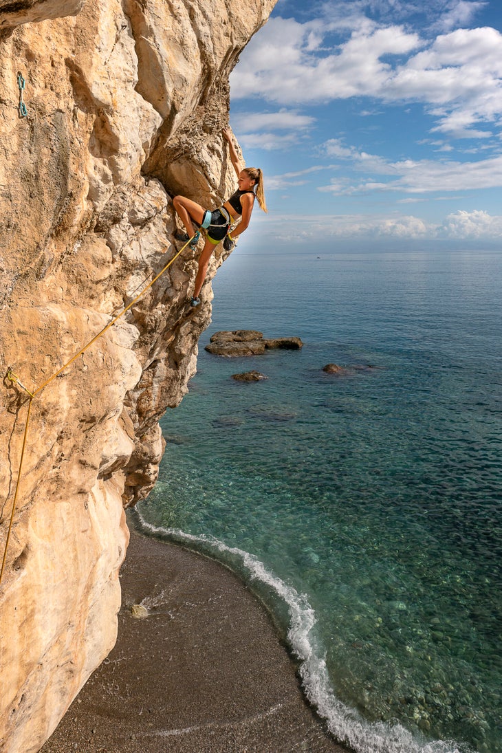 Woman goes rock climbing in Sicily.