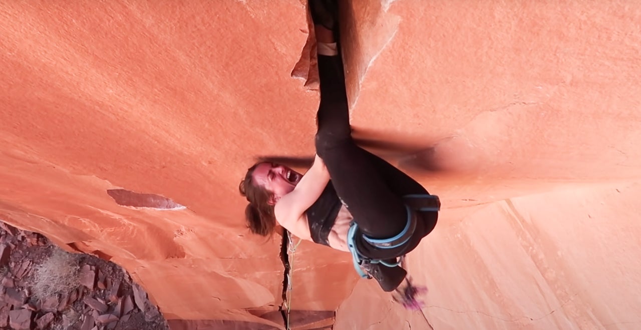 Woman climbs offwidth crack in Utah.