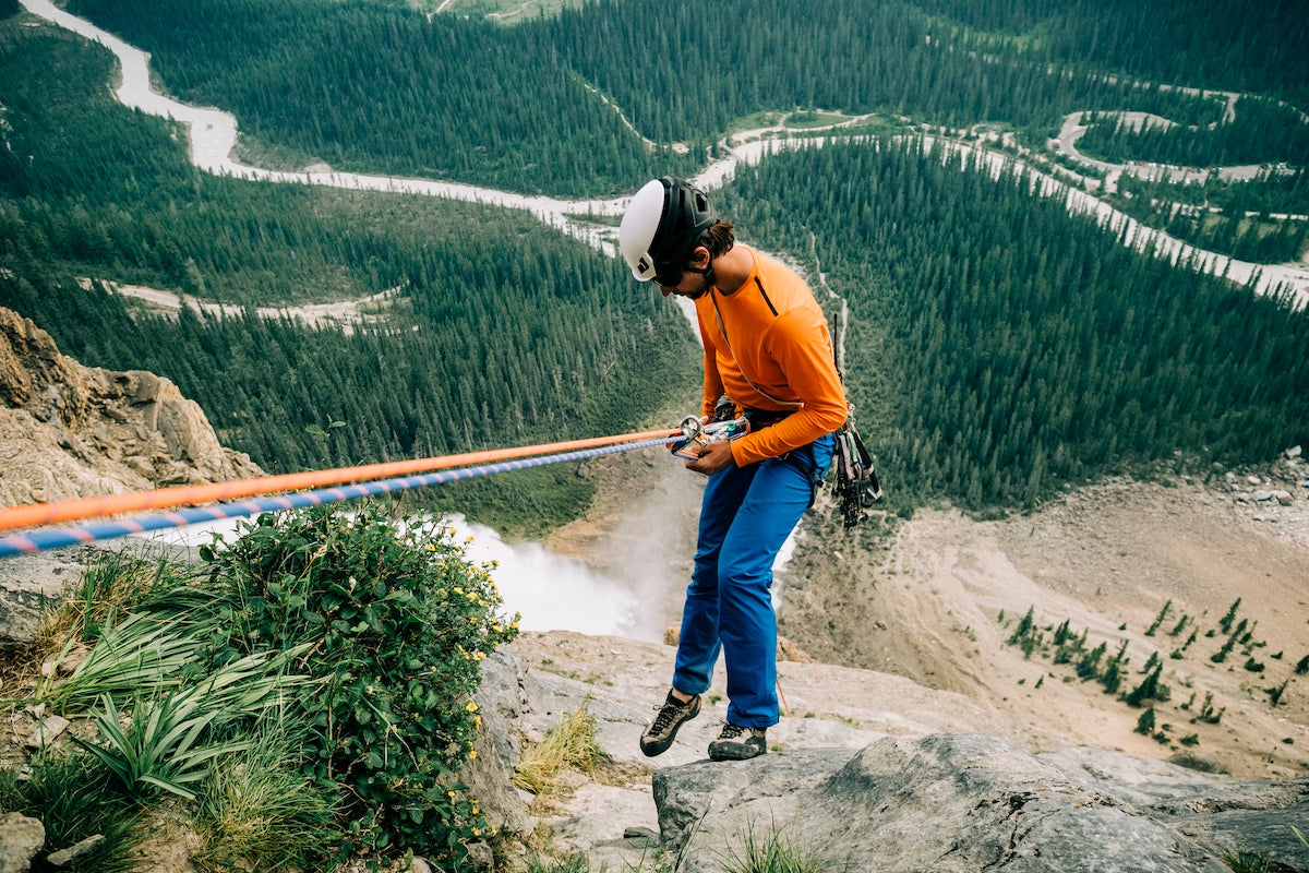 Male climber rappelling a big wall in Canada.