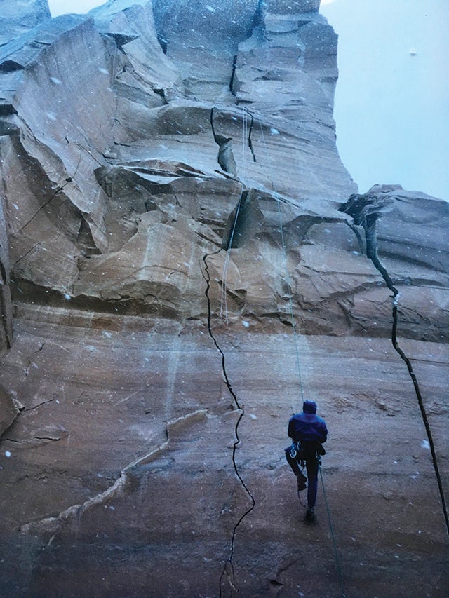 Climber ascending rope in lighting storm, north six shooter peak, Utah.