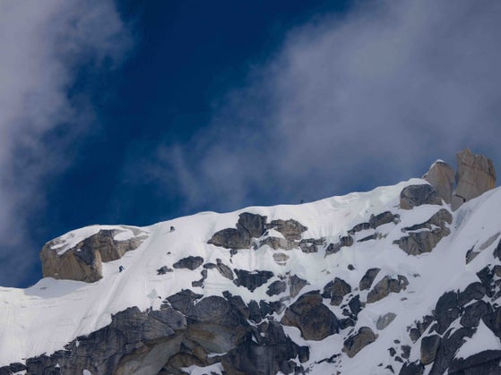 Three climbers on Kichatna Spire's summit ridge.