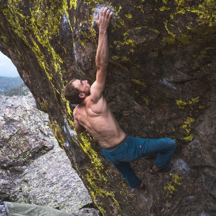 Rock climber climbs steep boulder in Colorado.