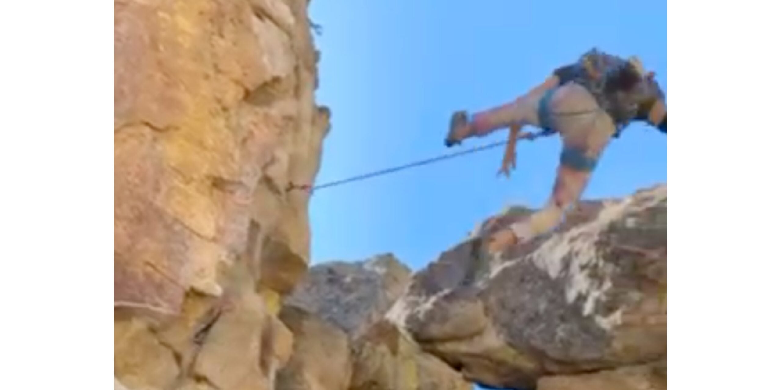 Man falls inverted down cliff face.