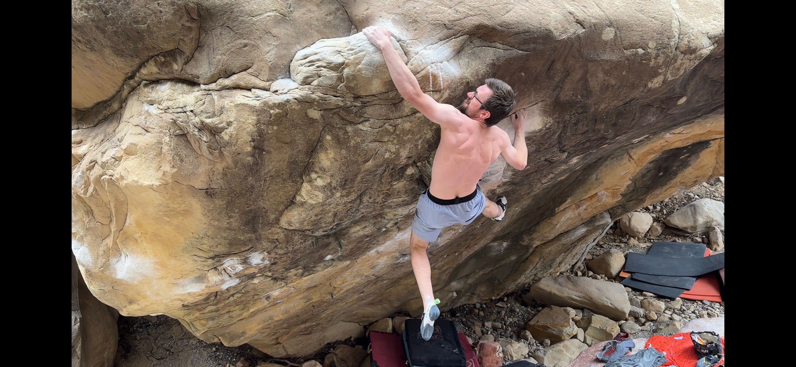 Will Bosi, shirtless, sticking the final hold on Daniel Wood's 'Return of the Sleepwalker' (V17)—one of the hardest boulder problems in the United States