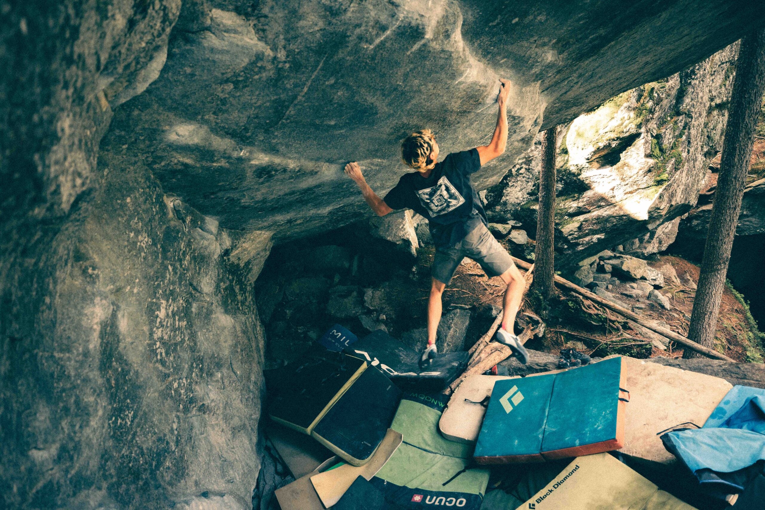 Male climber cuts feet below an overhanging boulder, becoming the first climber to flash V15.
