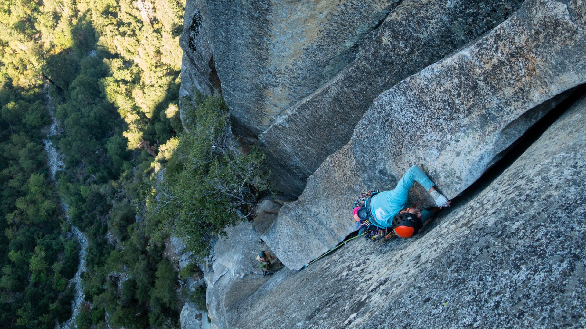 Climber in Yosemite ascends granite crag in the shade. Climbing grades helped them decide which route to do.