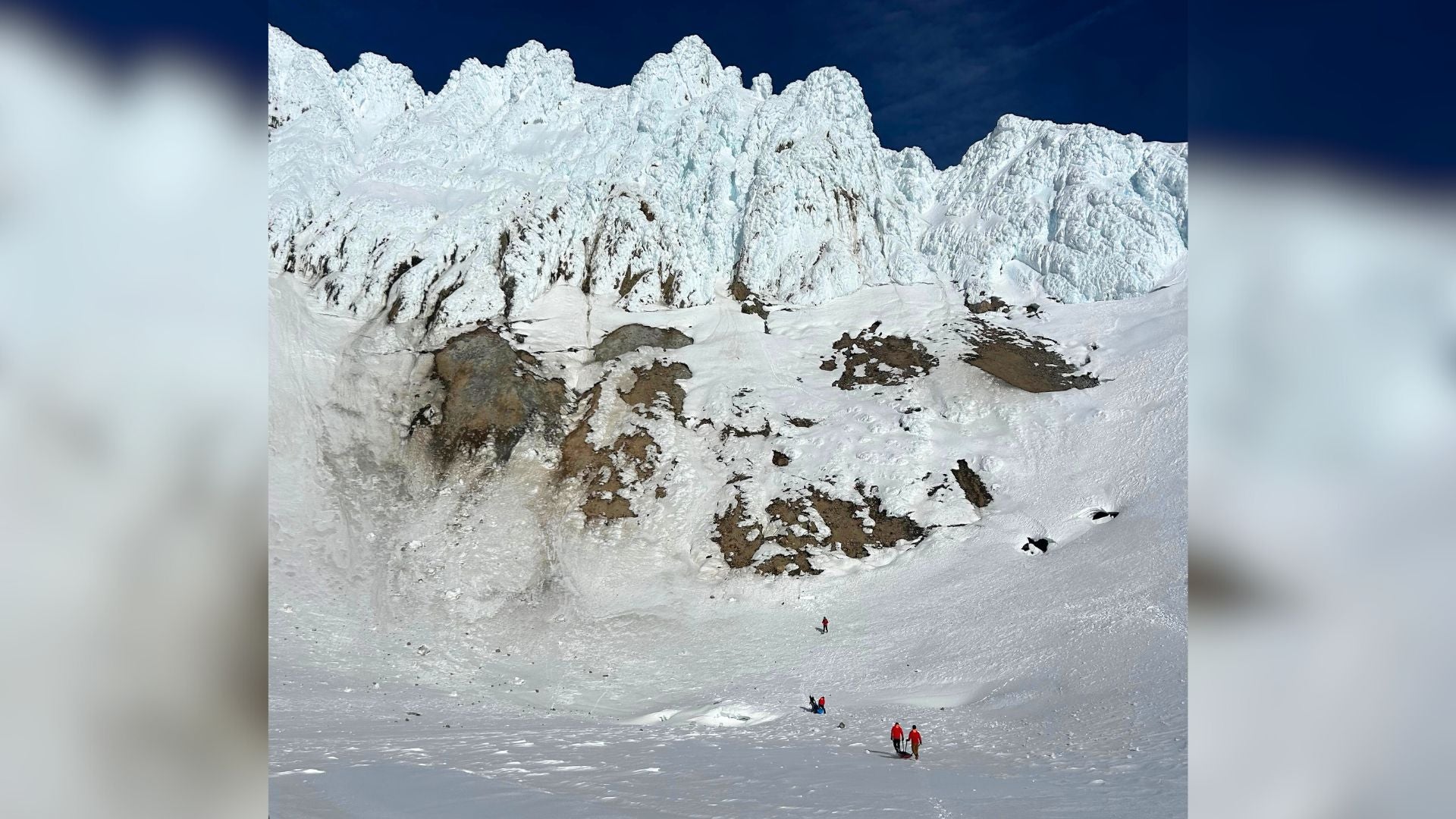 Portland Mountain Rescue workers approach the south side of Mount Hood. 'Devil's Kitchen Headwall Variation,' where the accident occurred, is the prominent gully system on the right.